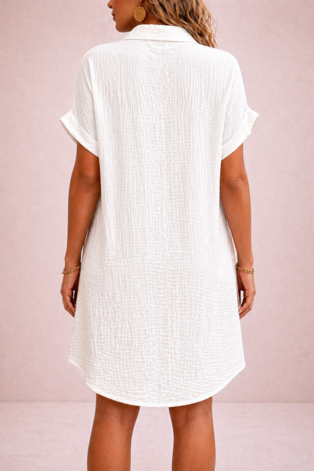 White short-sleeve dress worn by a person on a pink background