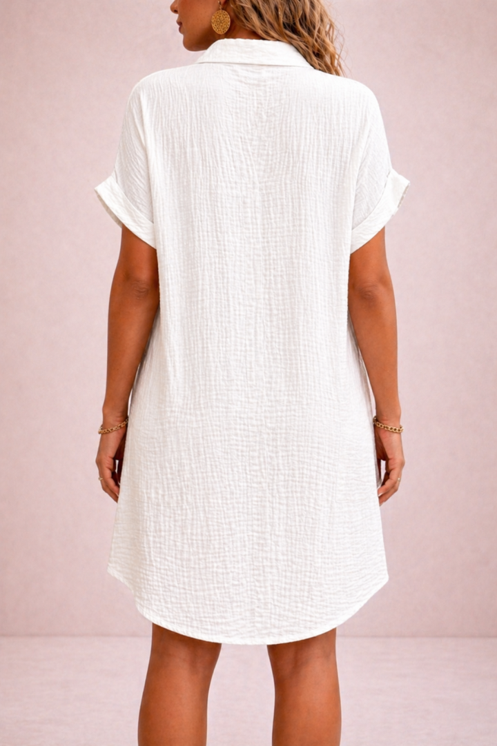 White short-sleeve dress worn by a person on a pink background
