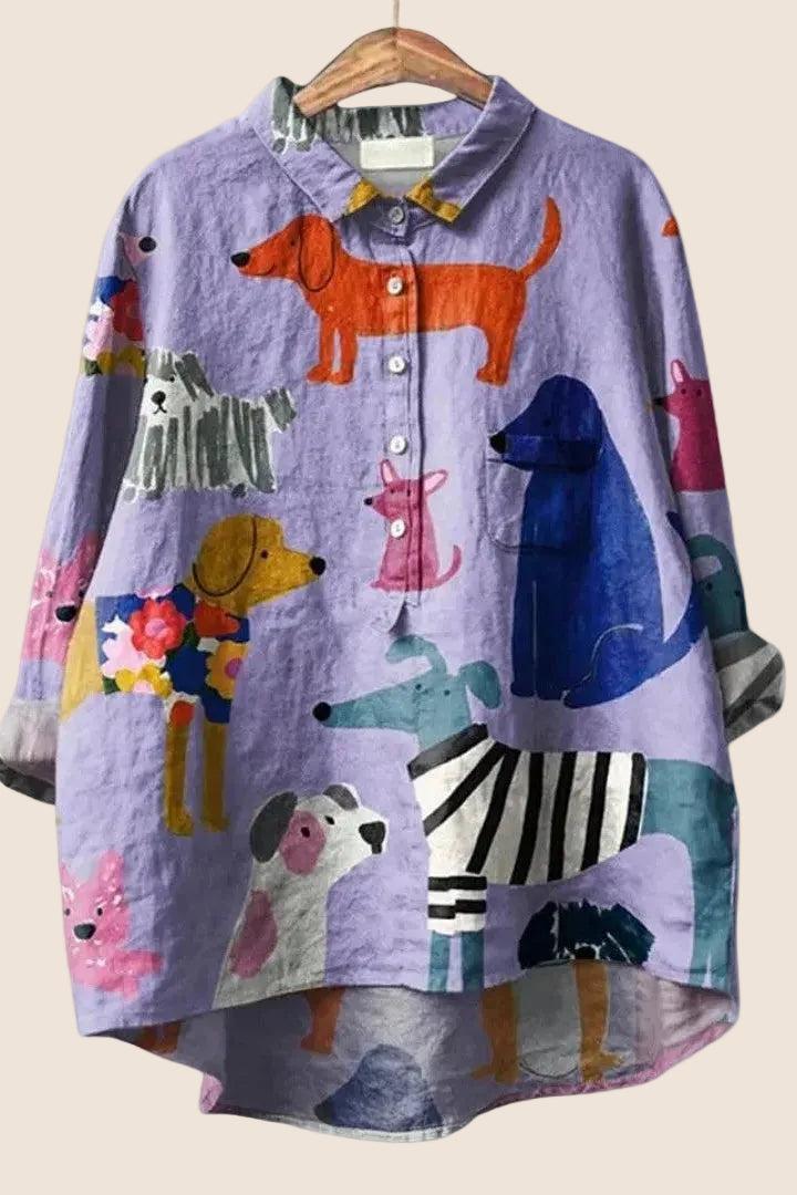 Colorful shirt with dog illustrations on a hanger against a white background