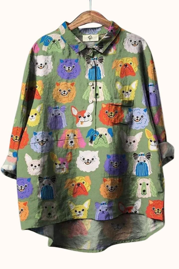 Green shirt with colorful dog pattern hanging on a white background