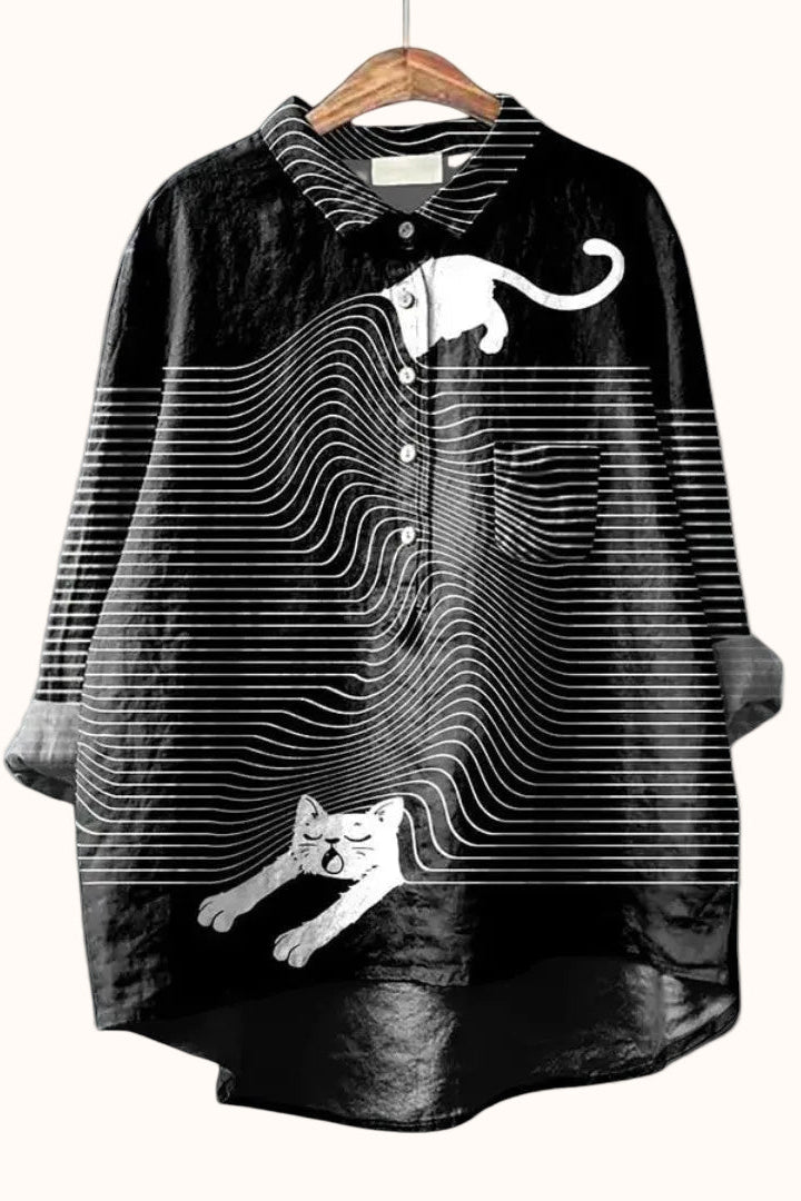 Black shirt with white cat design on a hanger against a light gray background