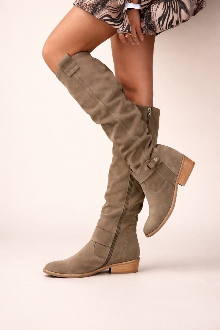Brown knee-high boots on a plain background