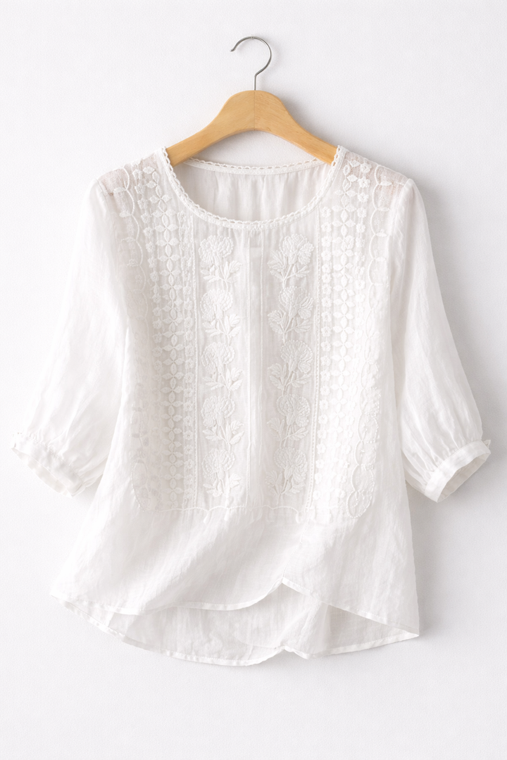 White blouse on a wooden hanger against a white background