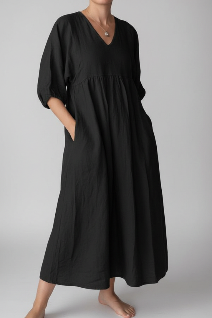 Person wearing a black dress on a plain background