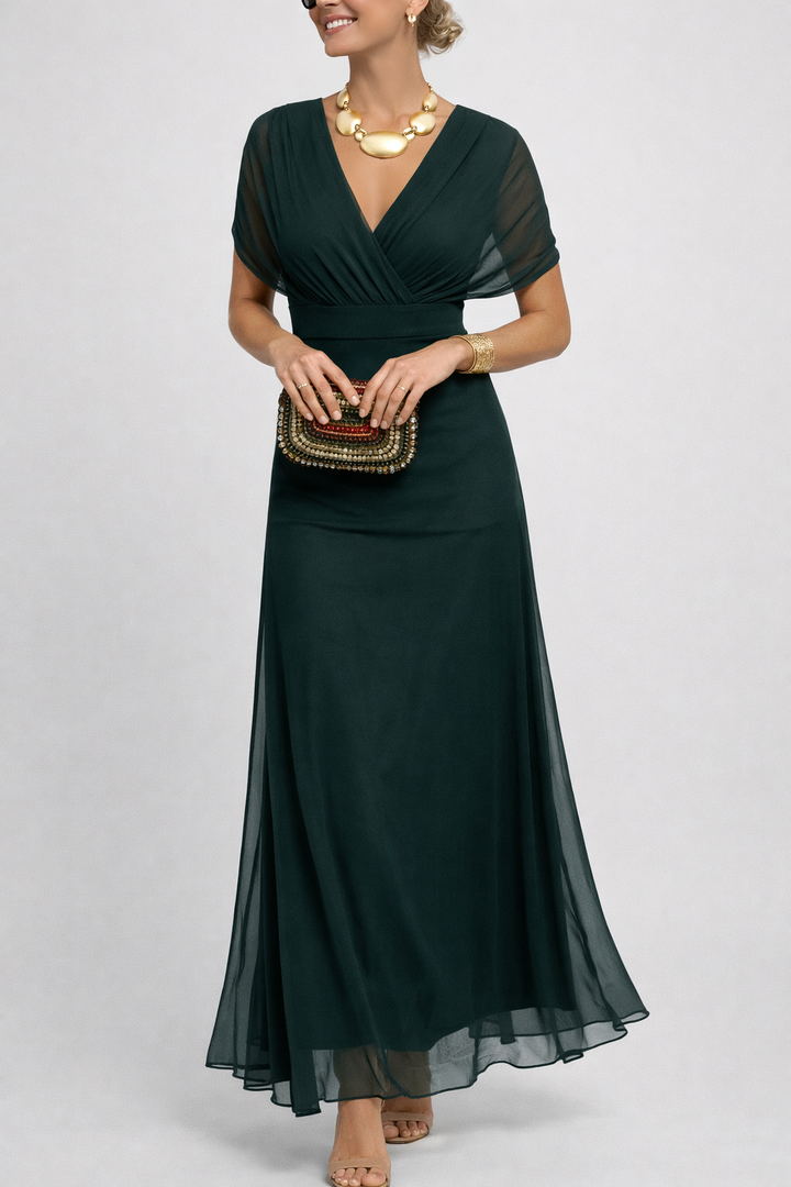 Woman wearing a dark green dress with a plain background