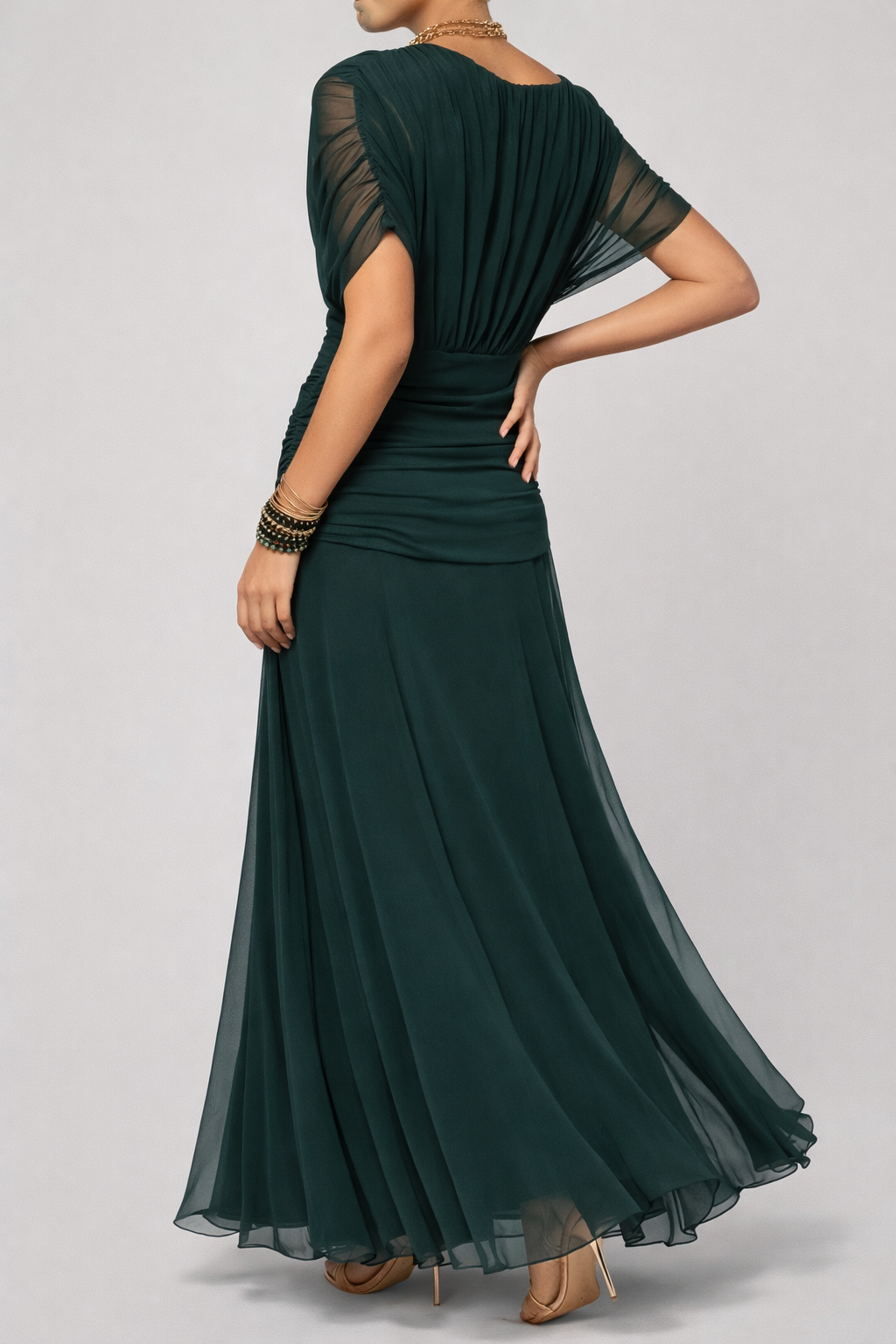 Green evening gown with sheer sleeves on a gray background