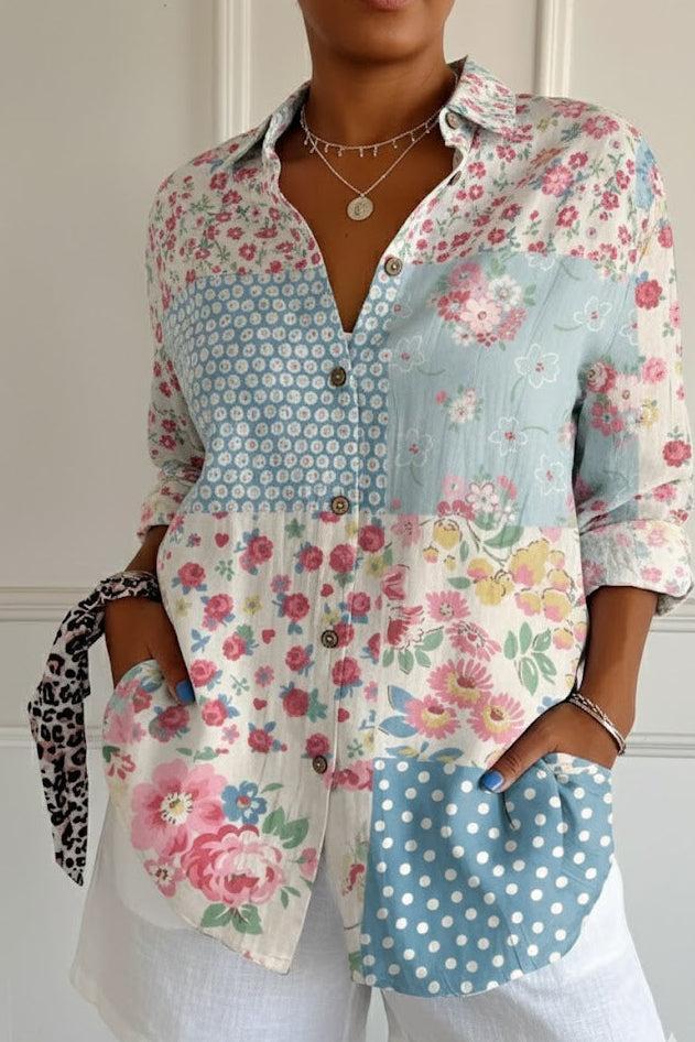 Person wearing a colorful floral and polka dot shirt with white shorts indoors.