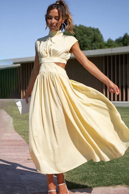 Woman in a yellow dress standing outdoors on a sunny day