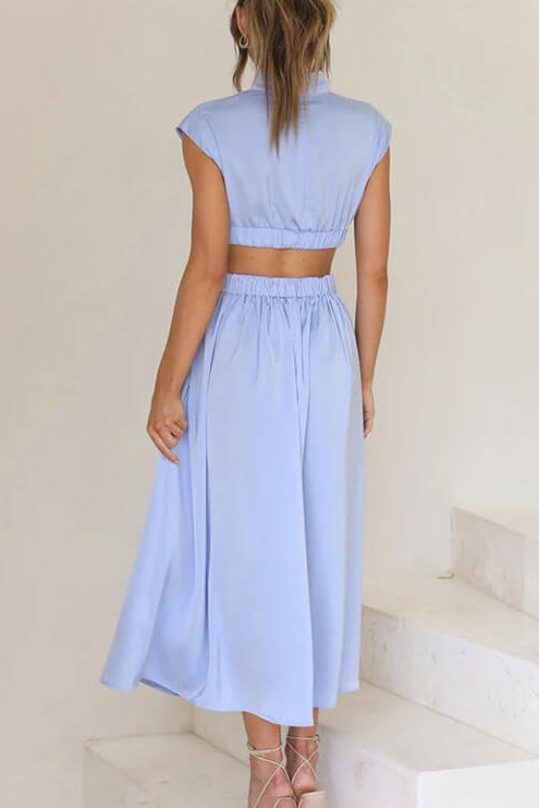Woman wearing a light blue dress standing on a staircase.