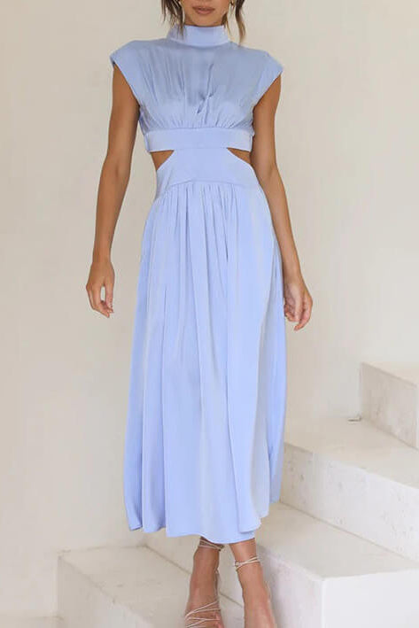 Woman wearing a light blue dress with cut-out design on a white staircase.